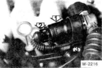 • Отсоедините разьем (2) от регулятора холостого хода (1). Фотография относится к двигателю М20, в двигателе М50 регулятор расположен под впускным коллектором.